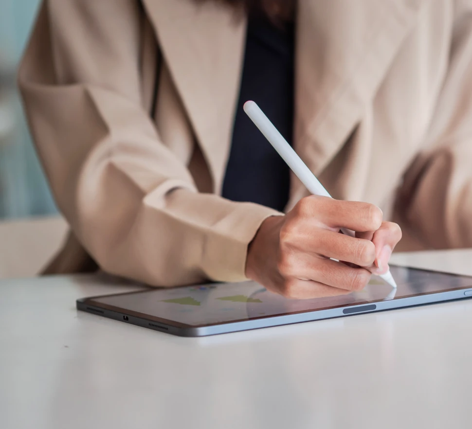 Photo of a person writing on a tablet with a tablet pen