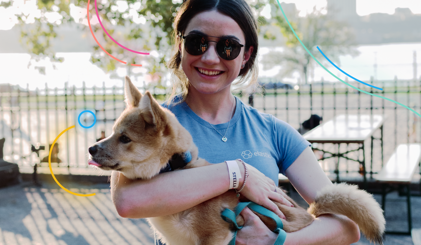 smiling woman enjoys work life balance holding a dog in a park